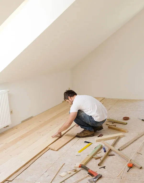 A man is working on the floor of his home.