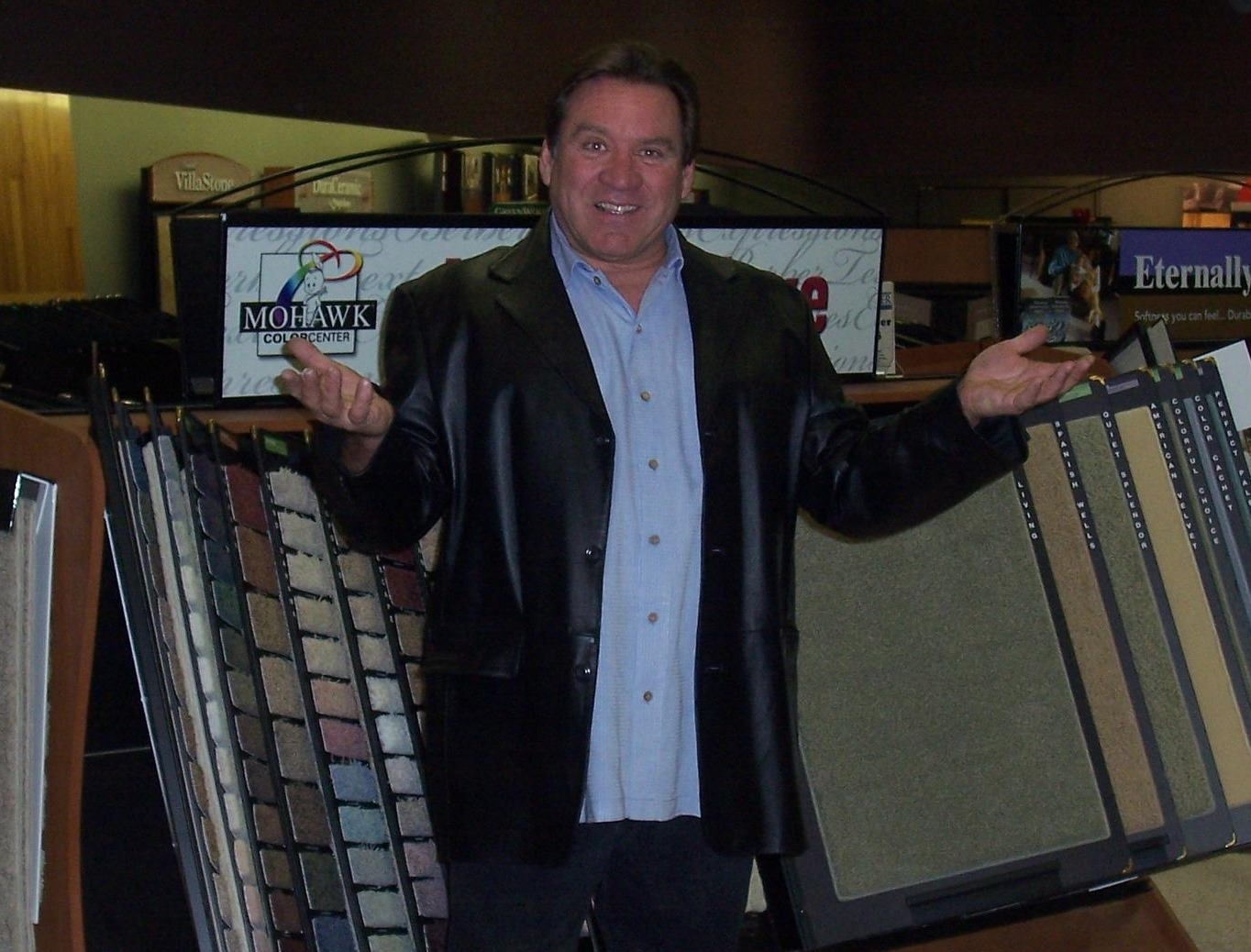 A man standing in front of several different types of flooring.