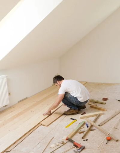 A man is working on the floor of his home.